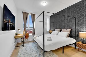 1 dormitorio con 1 cama blanca grande y escritorio en Deluxe Suites Downtown Montreal, en Montreal