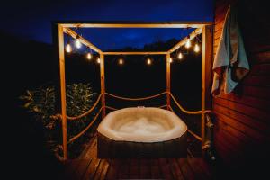 eine Badewanne auf einer Terrasse mit Beleuchtung in der Unterkunft Naturasort Holiday Houses in Pesnica pri Mariboru