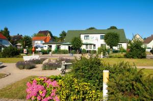 a house with a garden with flowers in front of it at App Seeblick in ruhiger Lage in Seedorf in Seedorf