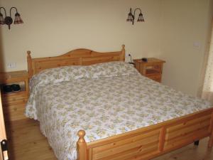 1 dormitorio con 1 cama de madera y 2 mesitas de noche en le balze di Carisolo, trilocale con giardino, en Carisolo