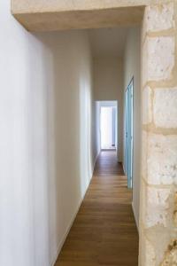 un pasillo con paredes blancas y suelo de madera en Apartment in hyper center - 3 bedrooms en Arles