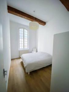 Habitación blanca con cama y ventana en Apartment in hyper center - 3 bedrooms en Arles