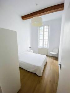 Un dormitorio blanco con una cama blanca y una ventana en Apartment in hyper center - 3 bedrooms en Arles