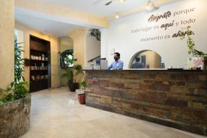 a man standing at the counter of a restaurant at Hacienda Paradise Hotel in Playa del Carmen