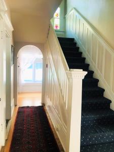 a hallway with a staircase with a black carpet at Windsor Guest House in Vancouver