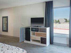 a hotel room with a television and a bed at Four Points by Sheraton Plano in Plano