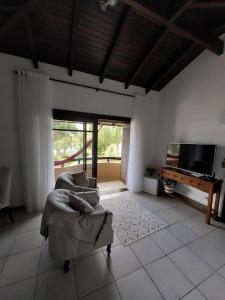 a living room with a couch and a television at Pousada Brisas do Rio in Torres