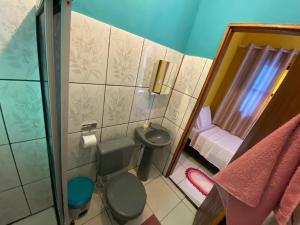 a small bathroom with a toilet and a sink at Pousada Pássaros da Manhã in Vale do Capao