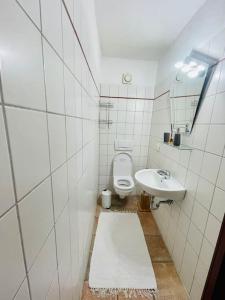 a white bathroom with a toilet and a sink at Helles Zweibettzimmer Nahe Magdeburg in Barleben