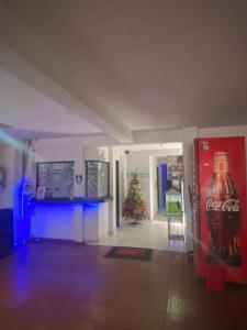 a room with a cocacola soda machine and a christmas tree at Residencias Piscis in Barranquilla