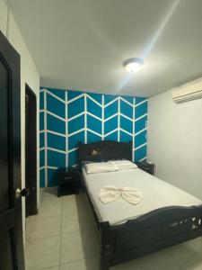 a bedroom with a bed with a bow on it at Residencias Piscis in Barranquilla