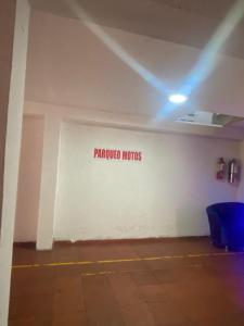 una habitación con una pared blanca con un cartel. en Residencias Piscis, en Barranquilla