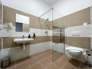 a bathroom with a shower and a toilet and a sink at Penzion MOVEINN in Prague