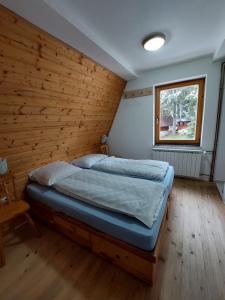 a bedroom with a bed in a wooden wall at Vikendica A Vlasic in Vlasic