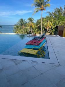 a swimming pool with lounge chairs and the ocean at De Olho no Mar A única pousada de frente para o mar em Paracuru in Paracuru