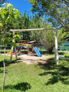 a playground in a park with a blue slide at CONDOMINIO WEMBLEY TENIS in Ubatuba