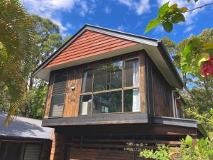 ein winziges Haus mit rotem Dach in der Unterkunft Beautifully Elevated Treehouse Apartment in Buderim