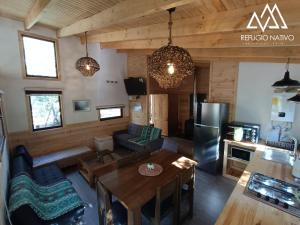 a living room with a table and a kitchen at Refugio Nativo in Nevados de Chillan