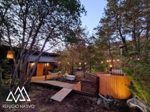 a backyard with a wooden deck and a house at Refugio Nativo in Nevados de Chillan