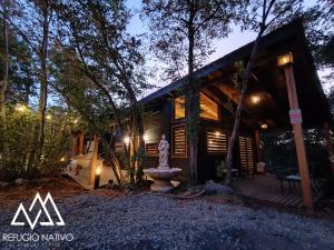 a house in the woods with a statue in front of it at Refugio Nativo in Nevados de Chillan