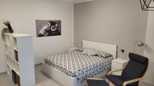 1 dormitorio blanco con 1 cama y 1 silla en Rifugio in città, en Módena