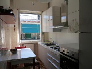 a kitchen with a sink and a stove and a window at Pietra Ligure in Pietra Ligure