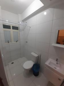 Baño blanco con aseo y lavamanos en Melhor Custo x benefício - Tompell Pousada Bem-te-vi - Portaria só até 22 horas, en Ponta Porã