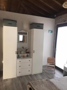 ein Schlafzimmer mit zwei weißen Schränken und einer Kommode in der Unterkunft Casa Escuela Trasmiras 
