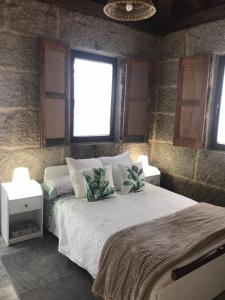 ein Schlafzimmer mit einem großen Bett mit zwei Nachttischen in der Unterkunft Casa Escuela Trasmiras 