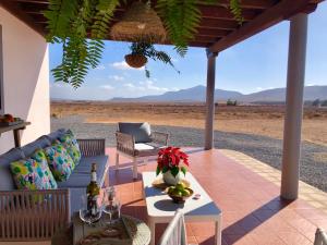 une terrasse avec un canapé, une table et une chaise dans l'établissement Tranquila casa rural en el centro de Fuerteventura, à Valles de Ortega