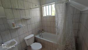 łazienka z toaletą, wanną i zasłoną prysznicową w obiekcie Casita de Sara w mieście Castro
