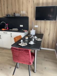 a black table with a red chair in a kitchen at Gästehaus Wind und Meer in Norddeich