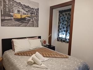 ein Schlafzimmer mit einem Bett mit zwei Handtüchern darauf in der Unterkunft Appartement Lisbonne Estrela in Lissabon