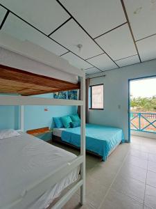 a bedroom with two bunk beds and a balcony at Cabañas Cigua in Coveñas