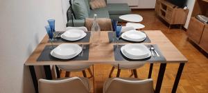 a dining room table with white plates and chairs at Brétema in Porriño