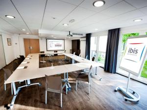 a large meeting room with long tables and chairs at ibis Maisons Laffitte in Maisons-Laffitte