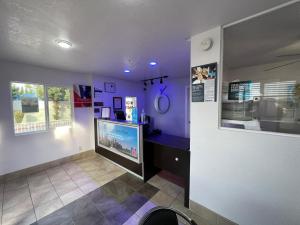a room with a tv in a room with purple walls at Motel 6-Orange, CA - Anaheim in Anaheim