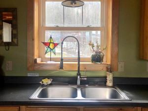 a kitchen sink and a window with a star on it at Morning Star Log Cabin in Nelson