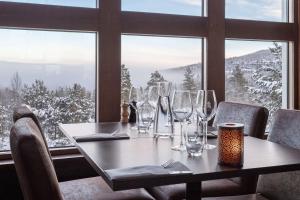 uma mesa com copos de vinho em frente a uma janela em Stoten Ski Hotel em Stöten