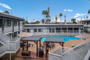 une piscine avec des tables et des parasols en face d'un bâtiment dans l'établissement SureStay Hotel Laredo by Best Western, à Laredo
