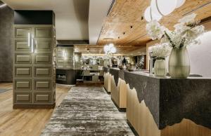 a large kitchen with a counter with vases of flowers at Grand Tirolia Kitzbühel - Member of Hommage Luxury Hotels Collection in Kitzbühel