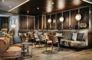 a restaurant with couches and tables and chairs at Grand Tirolia Kitzb&uuml;hel - Member of Hommage Luxury Hotels Collection in Kitzb&uuml;hel