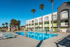 a swimming pool at a hotel with palm trees at SureStay Plus Hotel by Best Western Scottsdale North in Scottsdale