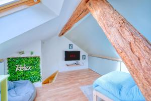 Habitación con cama y TV en el ático en "Offre Grand Bal Masqué" Spacieux Duplex vitaminé en Jouy-en-Josas