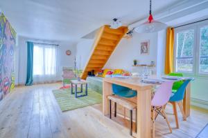 sala de estar con mesa y sillas y escalera en "Offre Grand Bal Masqué" Spacieux Duplex vitaminé en Jouy-en-Josas