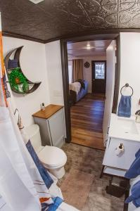 a bathroom with a toilet and a sink and a bed at The Free Spirit Retreat in Newaygo