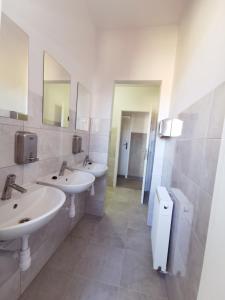 La salle de bains est pourvue de 2 lavabos et de 2 miroirs. dans l'établissement Komfortowa kwatera, à Stęszew