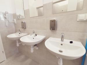 łazienka z 2 umywalkami i lustrami na ścianie w obiekcie Komfortowa kwatera w mieście Stęszew