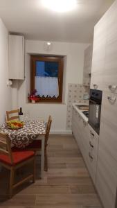 a kitchen with a table and a dining room at Desy miniapp Full a 2km da Pedavena in Pedavena +5 photos