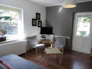 een woonkamer met 2 stoelen, een tafel en een televisie bij Cosy holiday home in Brilon with garden and barbecue in Brilon
